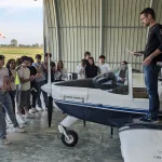 La classe davanti ad un piccolo velivolo con l'istruttore in piedi sull'ala